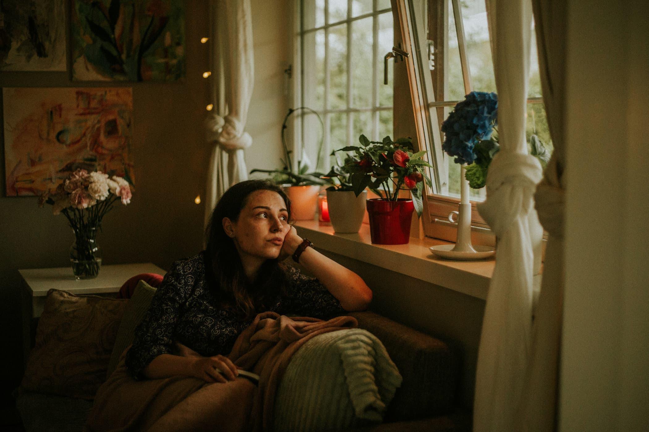 A person looking stressed sitting on a couch doing nothing